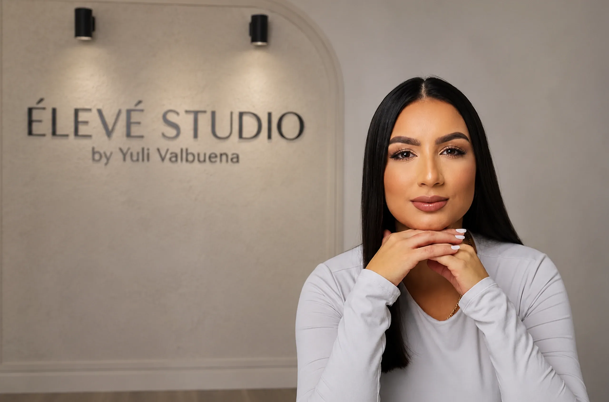 Yuli Valbuena, fundadora de Élevé Studio, en el estudio junto al letrero de la marca